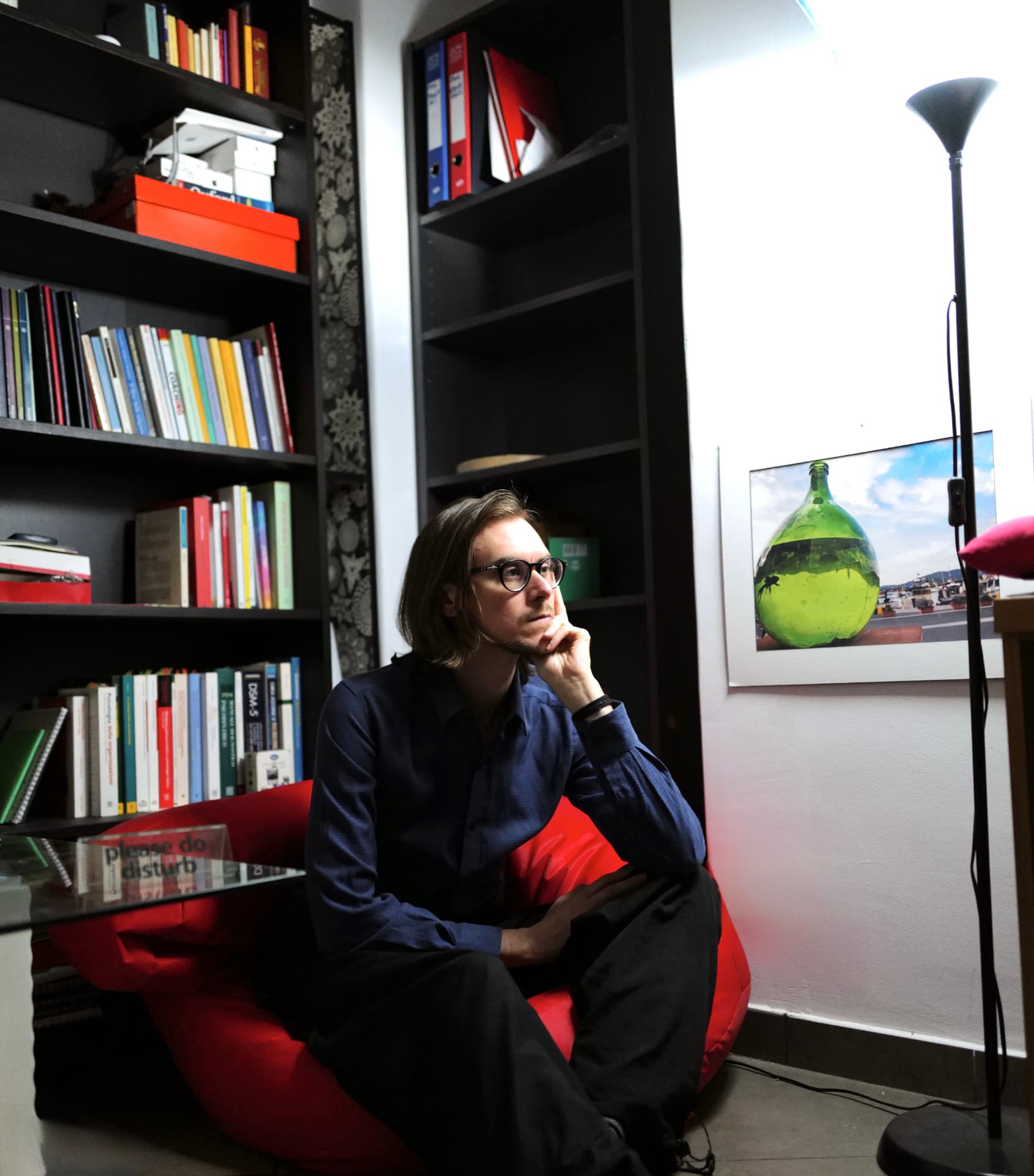 Marcello Paltrinieri seduto nel suo studio, accanto alla libreria